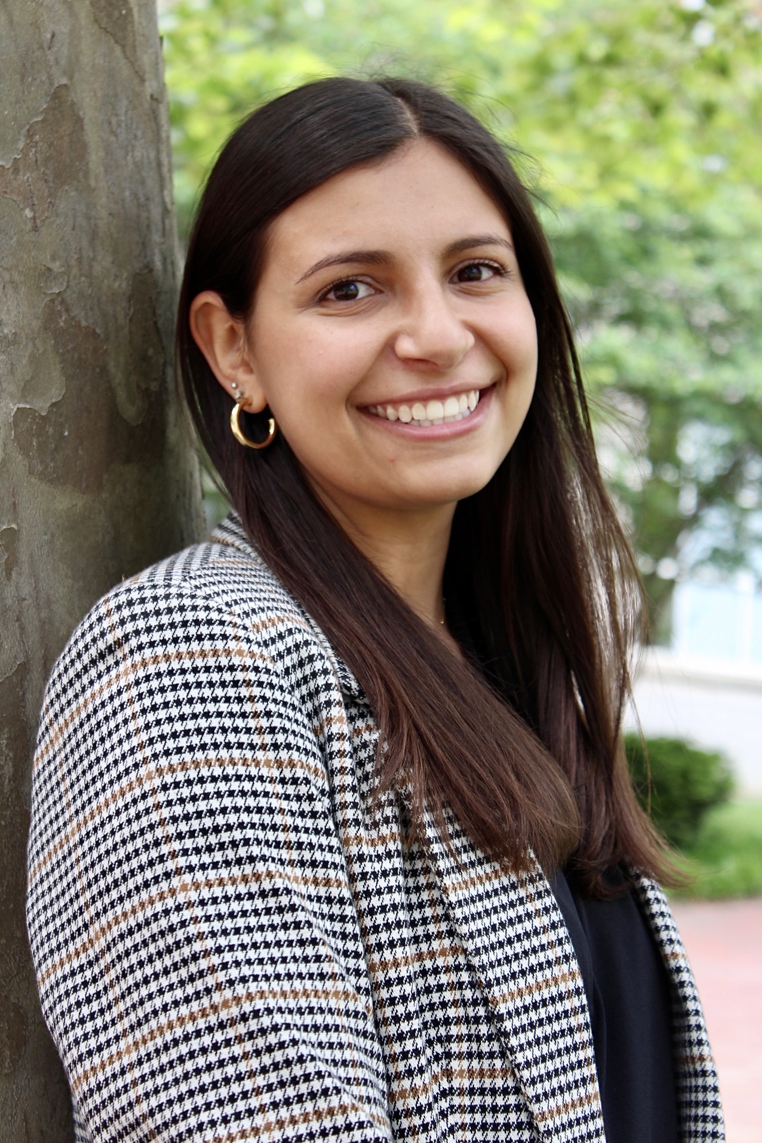Becca leaning against a tree